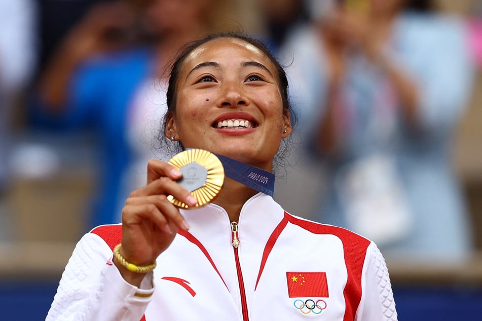 Zheng Qinwen of China poses with her medal after winning gold in the women's singles tennis final at the Paris Olympics.