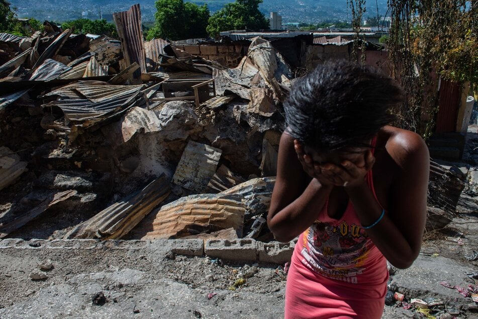 A woman cries outside her house after armed gangs set it on fire in the Post Marchand neighborhood of Port-au-Prince on December 17, 2024.