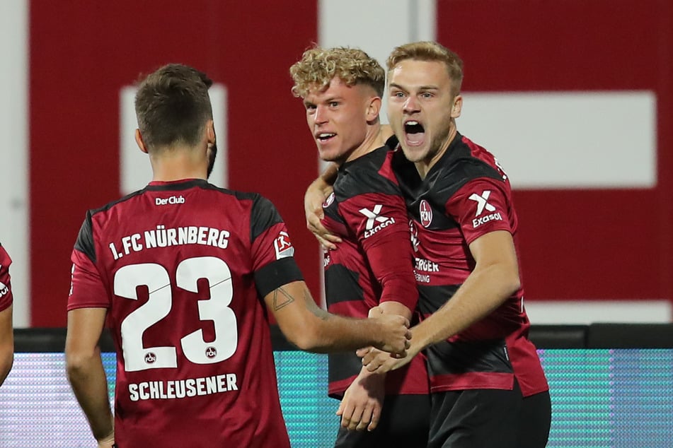 Robin Hack (M.) jubelt mit seinen Nürnberger Kollegen Fabian Schleusener (l.) und Tim Handwerker über seinen Treffer zum 1:0.
