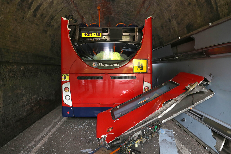 Das Dach eines Doppeldecker-Busses liegt in der Well House Lane neben dem Bus.