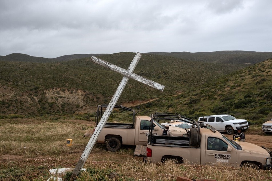 A wooden cross is seen next to Army trucks near the scene where human remains were found near La Bocana Beach in Ensenada, Baja California, Mexico.