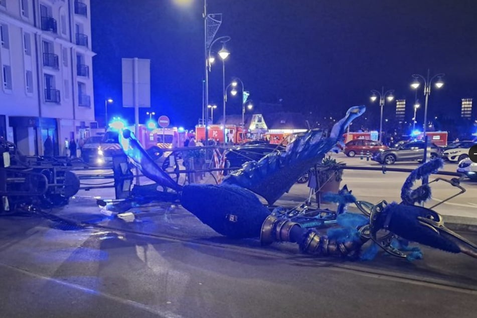 Vermutlich beim Abbiegen gekippt: Der Festwagen, ein aus Metall geformter Vogel, begrub mehrere Menschen unter sich.