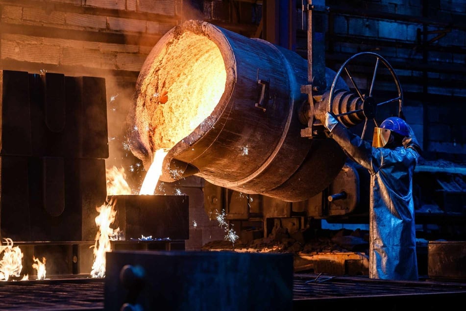 In der Produktionshalle der GL Gießerei Lößnitz. Ein Mitarbeiter kippt die Eisenschmelze in eine Gussform. Die europäische Stahlindustrie ist massiv unter Druck durch billige Importe aus China, Indien und Gussteile aus der Türkei.