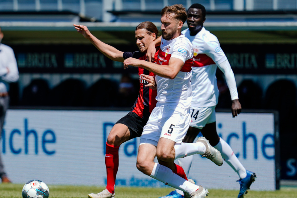 Wiesbadens Tobias Schwede (l) und Stuttgarts Nathaniel Phillips kämpfen um den Ball.
