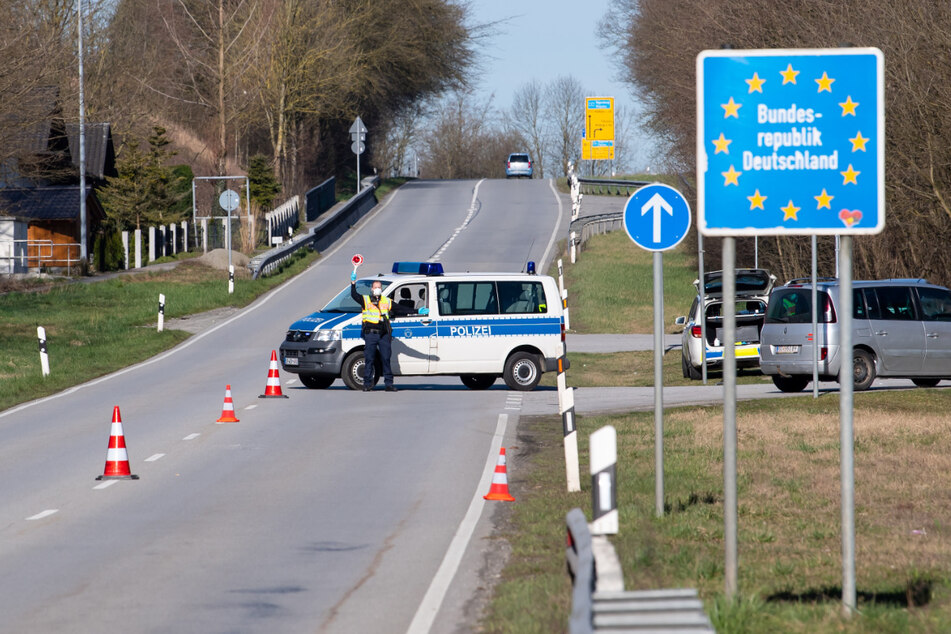 Polizisten stehen an der Bundesstraße 512 in der Nähe von Neuhaus am Inn an einer Kontrollstelle an der Grenze zu Österreich.