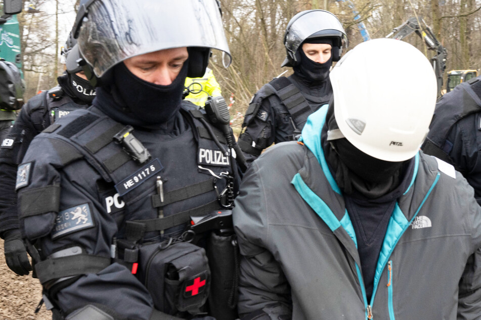 Polizisten führen einen Baumbesetzer aus dem Wald - die Räumung des besetzten Teilstücks des Fechenheimer Waldes in Frankfurt am Main zog sich über mehrere Tage hin.