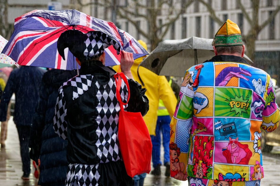 Vielerorts fing es in Köln richtig an zu schütten - die Jecken machten sich mit Regenschirmen auf den Heimweg.