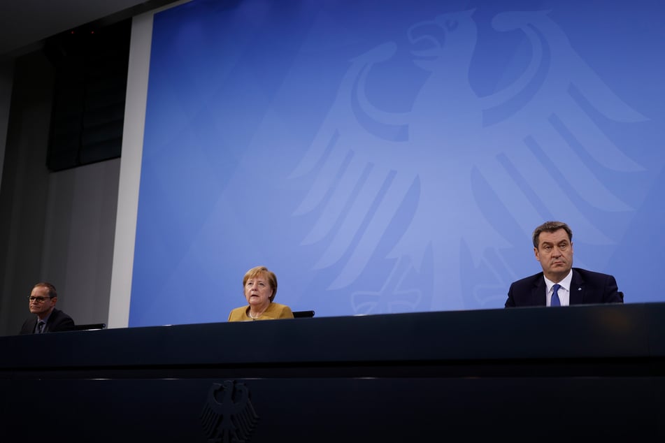 Bundeskanzlerin Angela Merkel (CDU) spricht im Bundeskanzleramt in der Pressekonferenz neben Bayerns Ministerpräsident Markus Soeder (CSU, r.) und Berlins Regierendem Bürgermeister Peter Müller (SPD, l.).