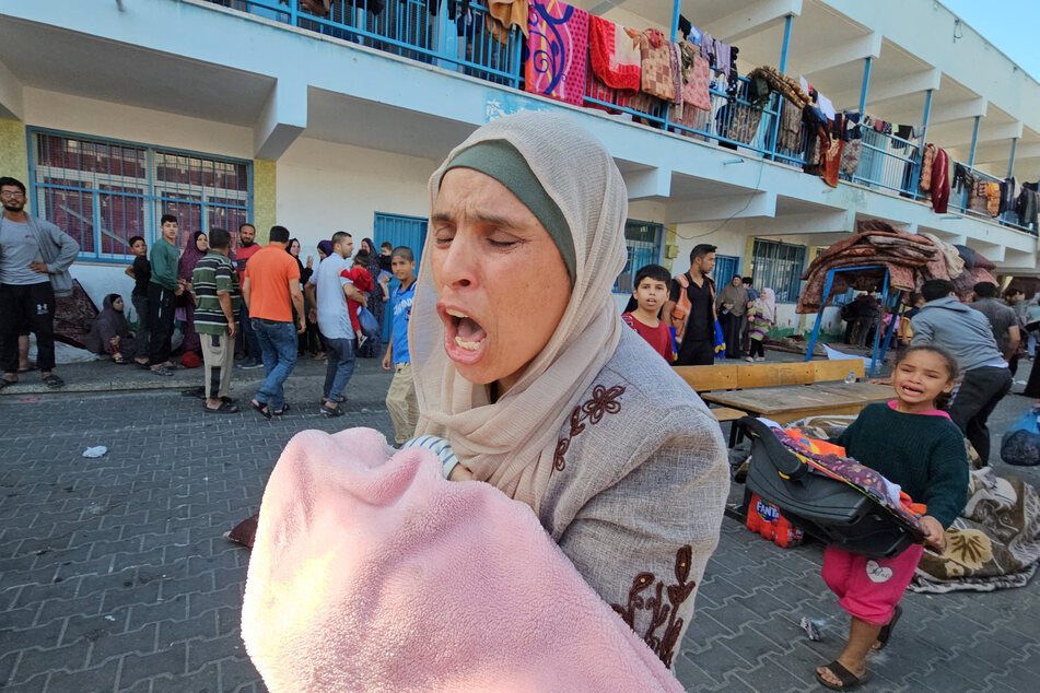 Palestinians react following an Israeli strike at a UN-run school sheltering displaced people in the Jabalia refugee camp in the northern Gaza Strip.