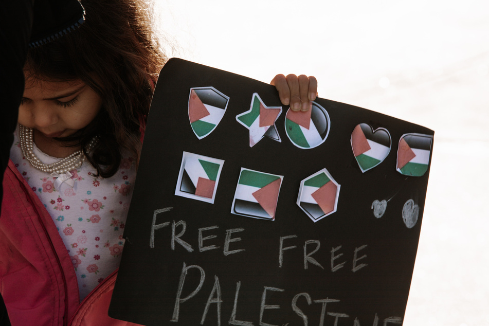 A child holds a sign reading "Free Free Palestine" during the rally and press conference at the Arizona State Capitol.