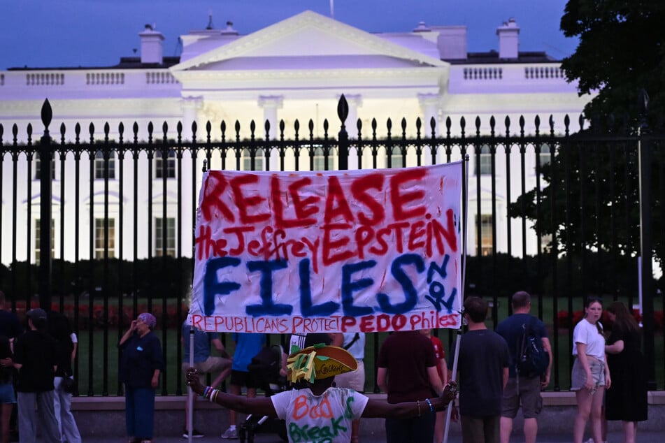 A protester holds a sign outside the White House demanding the release of all files related to Jeffrey Epstein.