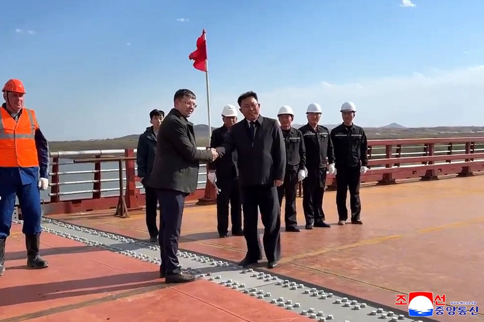 Vertreter Russlands und Nordkoreas auf einer Straßenbrücke, die die Grenze zwischen Nordkorea und Russland verbindet.