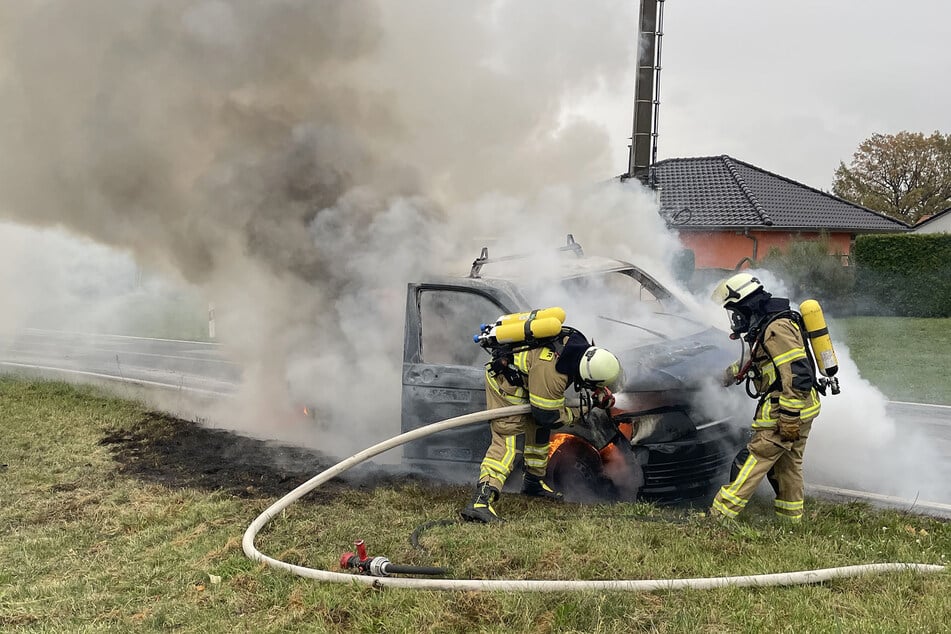 Unter schwerem Atemschutz nahm die Feuerwehr die Brandbekämpfung am VW-Kleintransporter auf.