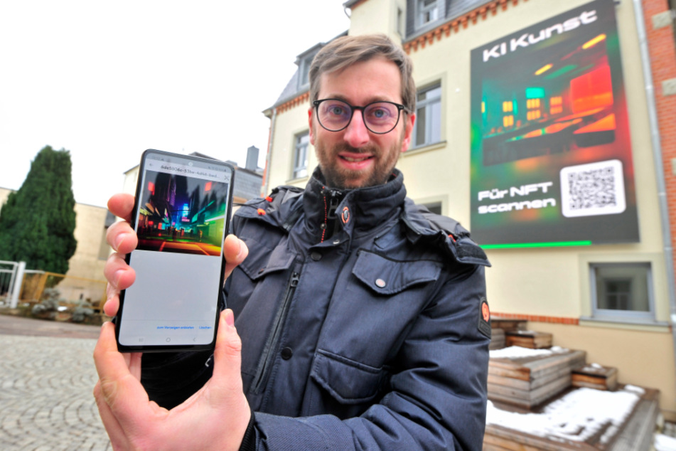 Einzigartige Kunst aus künstlicher Intelligenz: Jan Lippert (36) hat sich gerade ein Bild von der LED-Wand aufs Telefon gezogen.