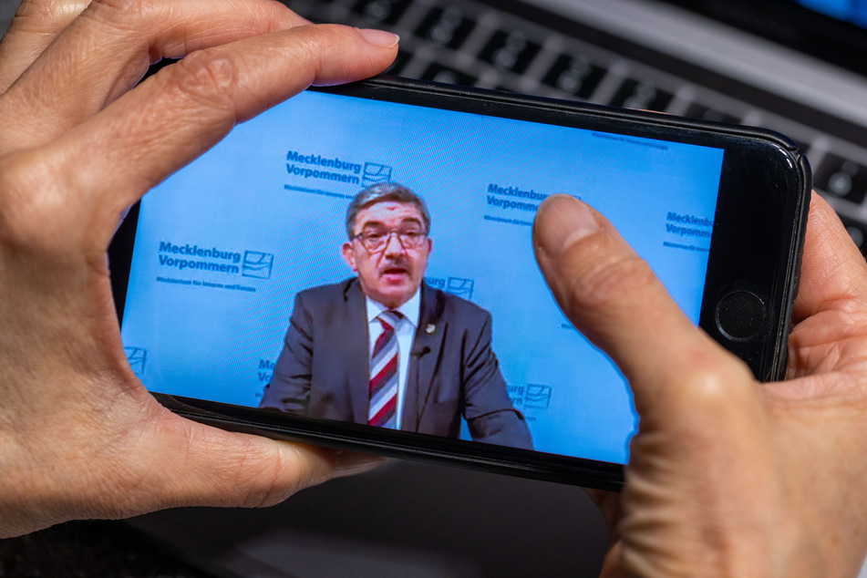 Auf dem Monitor eines Smartphones ist Lorenz Caffier (CDU) zu sehen.