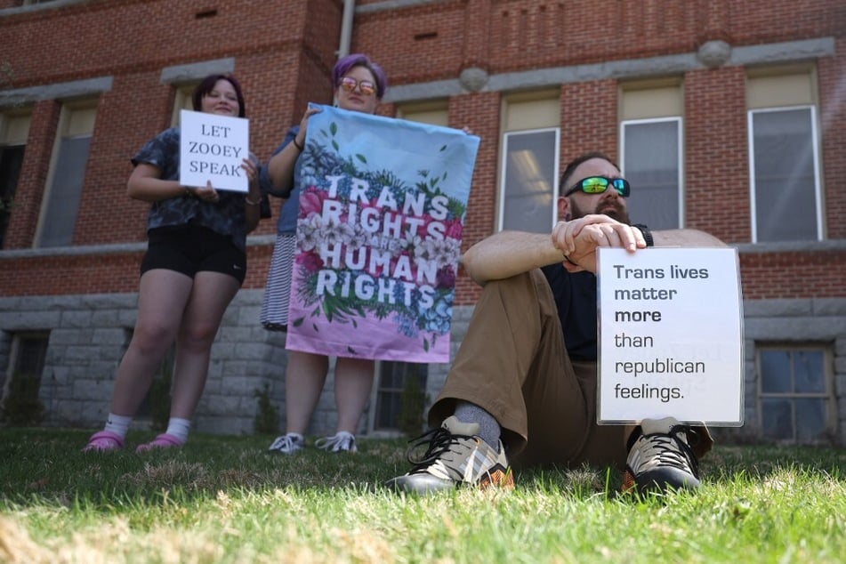 Transgender rights activists hold signs during a demonstration on the University of Montana campus in Missoula.