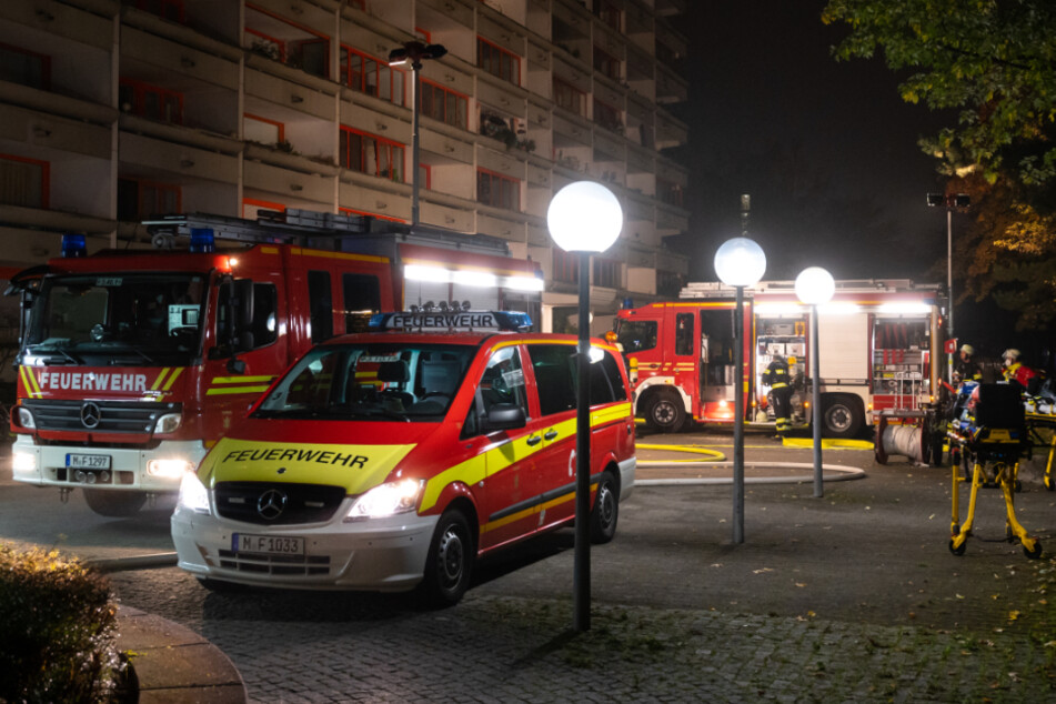 Einsatzkräfte der Feuerwehr stehen vor einem Hochhaus in der Hauzenberger Straße. In der Tiefgarage und in einer Wohnung hat es gebrannt.