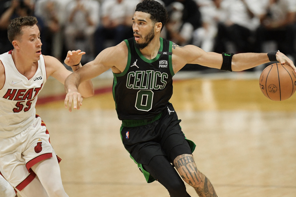 The Celtics' Jayson Tatum drives against the Heat's Duncan Robinson.
