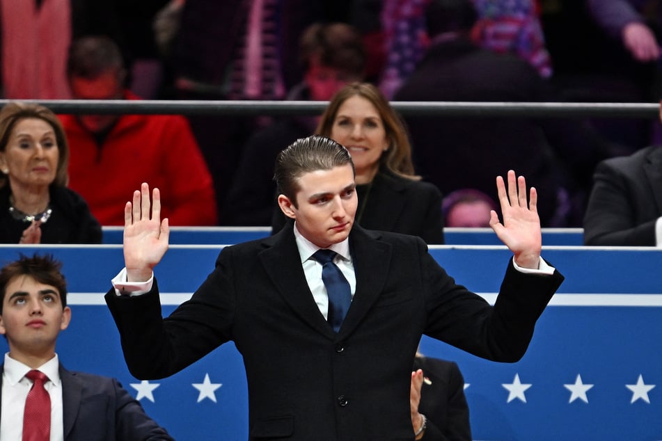 Barron Trump gestures after being acknowledged by Donald Trump during the inaugural parade at Capital One Arena in Washington DC on January 20, 2025.