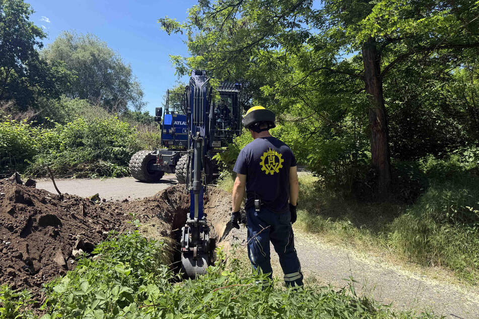 Das Technische Hilfswerk rückte mit einem Bagger an, um die Erde oberhalb des Rohrs abzutragen. Dafür musste auf ein Asphalt-Weg aufgebaggert werden.