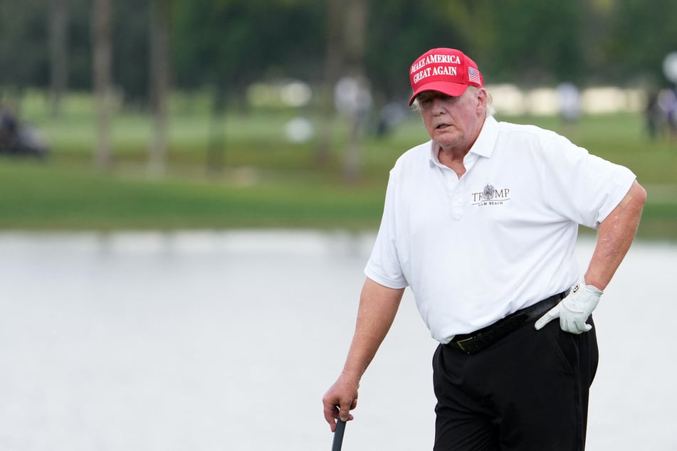 Former President Donald Trump stands on the 18th green during the Pro-Am tournament before the LIV Golf series at Trump National Doral.