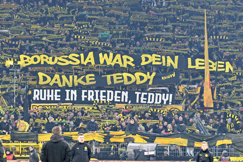 In Erinnerung an den verstorbenen Ex-Spieler und Torwarttrainer Teddy de Beer (†60) halten die BVB-Fans vor dem Anpfiff mehrere Banner hoch.