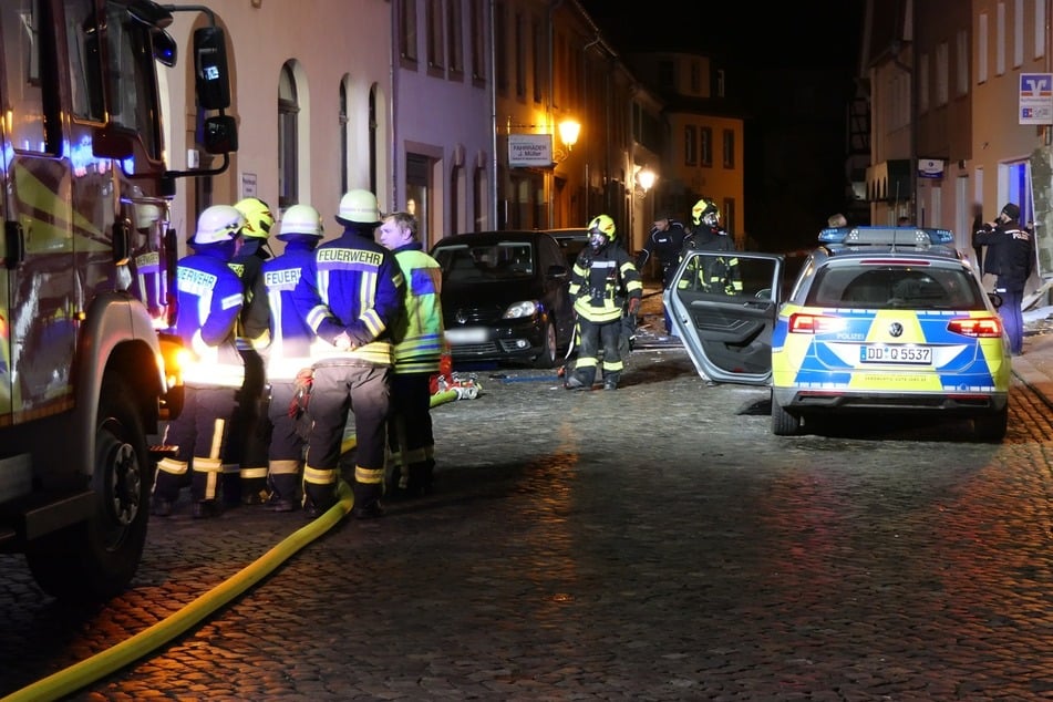 Einsatzkräfte von Polizei und Feuerwehr in der Nacht zu Heiligabend in der Badergasse in Colditz, wo Unbekannte zuvor die Raiffeisen-Filiale gesprengt haben.