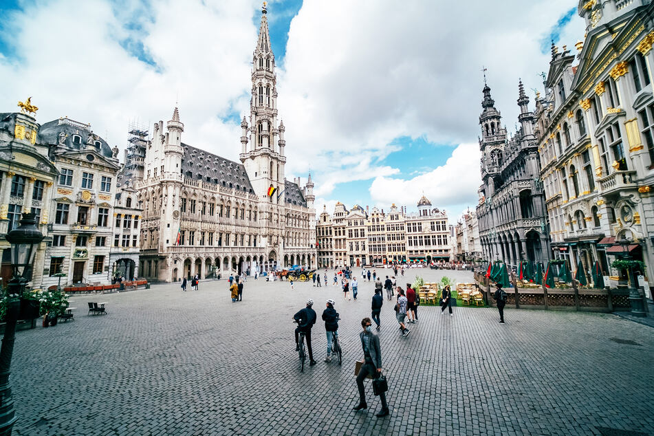 Touristen und Passanten sind auf dem Grand-Place, den zentralen Platz von Brüssel, unterwegs.