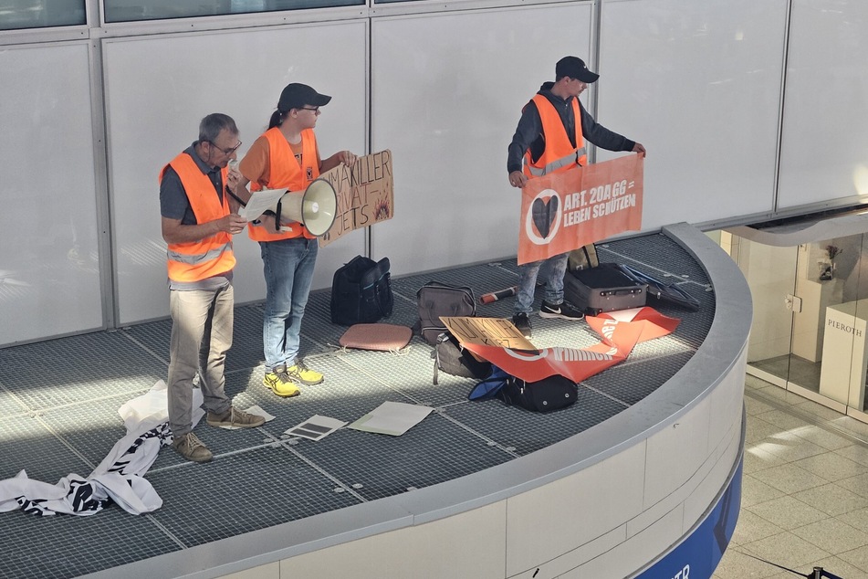 Mit Plakaten und einem Megafon verbreiteten drei Aktivisten ihre Mission.