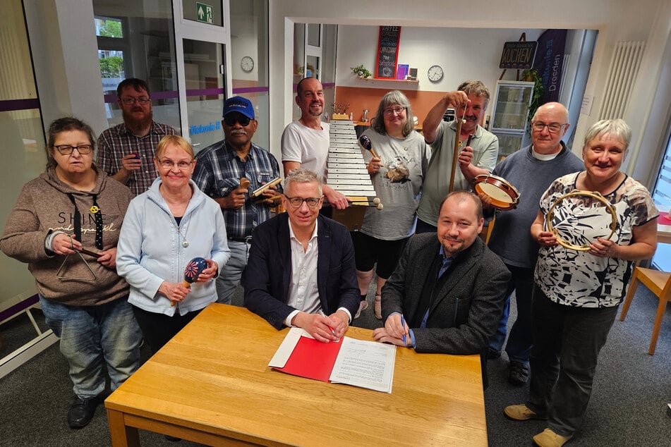 Jörg Polenz (61, v.l.), Chef des Palais Sommers, und Pfarrer Thomas Slesazeck (50), Geschäftsführer Diakonie Dresden, unterzeichnen vor dem versammelten Ensemble der "Königskinder" den Vertrag zur zukünftigen Zusammenarbeit.