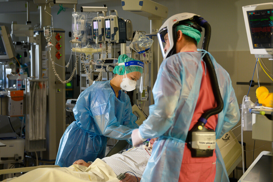 Eine Intensivpflegerin und ein Facharzt sind auf der Covid-19-Intensivstation im Städtischen Klinikum Dresden versorgen einen Corona-Patienten.