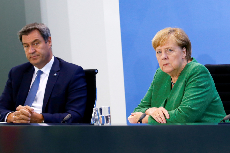 Bundeskanzlerin Angela Merkel (CDU) sitzt mit dem bayerischen Ministerpräsidenten Markus Söder (CSU) bei einer Pressekonferenz im Kanzleramt.