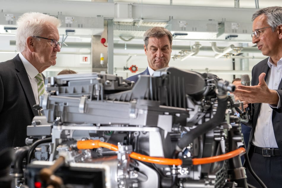 Winfried Kretschmann (l.) und Markus Söder (M.) ließen sich auch im Zentrum für Sonnenenergie- und Wasserstoff-Forschung von Vorstandsmitglied Markus Hölzle das Brennstoffzellensystem für Fahrzeugantriebe erklären.
