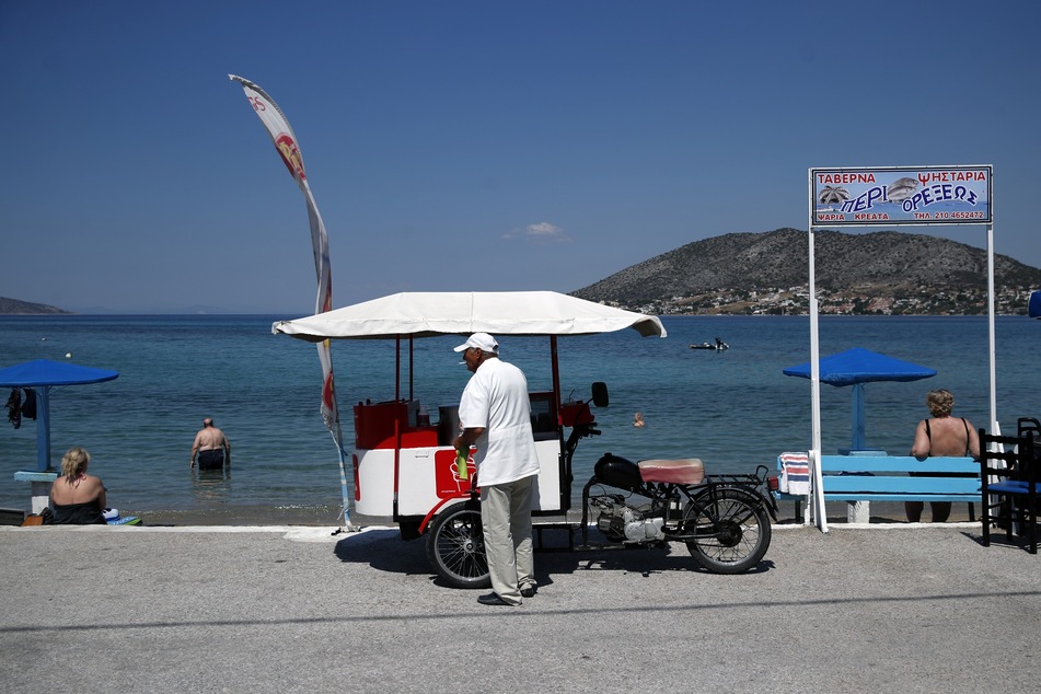 Ein Eisverkäufer wartet am Strand von Griechenland auf Kundschaft.
