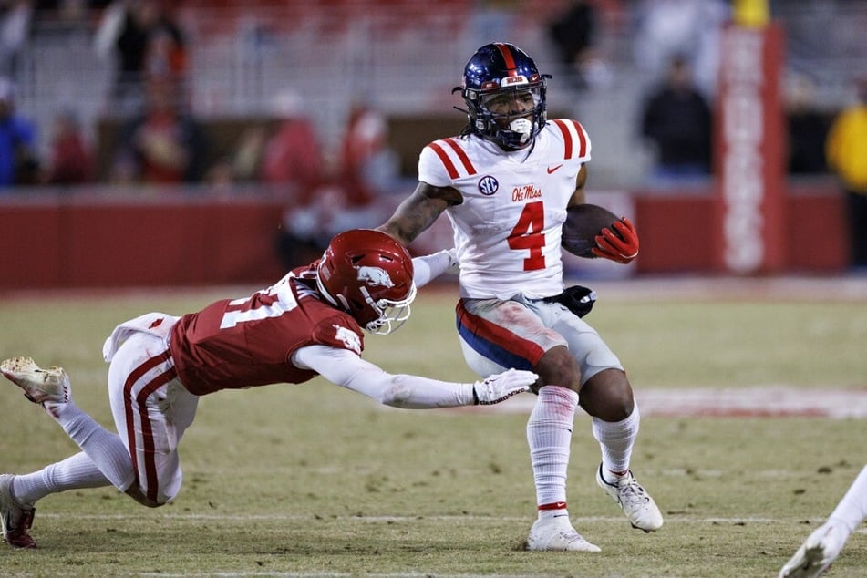 True freshman Quinshon Judkins (r.) runs the ball as Hudson Clark of the Arkansas Razorbacks goes for the tackle.