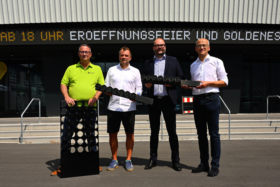 Feierliche Einweihung des LED-Lichtbandes am Heinz-Steyer-Stadion. Sportbürgermeister Jan Donhauser, DSC-Abteilungsleiter Marcus Zillich, Landesverbands-Präsident American Football Christian Piwarz und Stadtrat Peter Lames halten Teile der alten Anzeigetafel in den Händen.