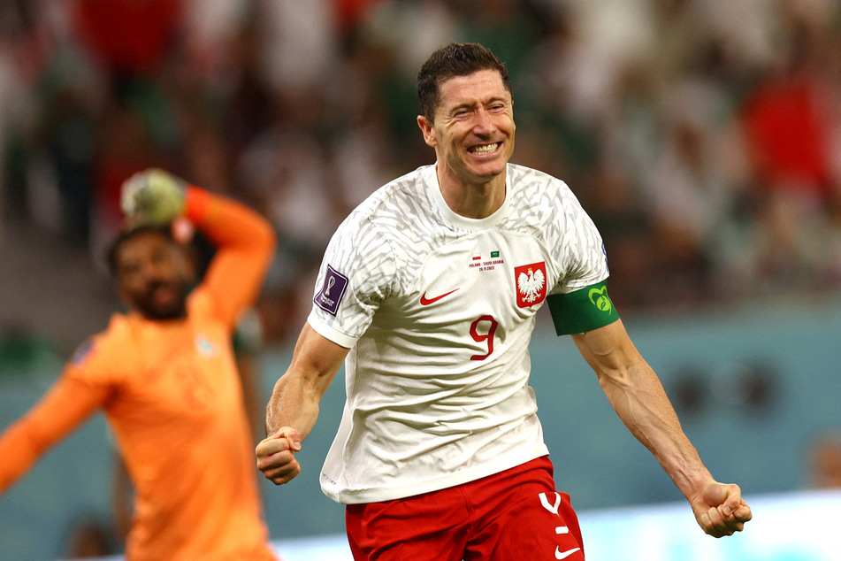 Poland's Robert Lewandowski celebrates scoring their second goal as Saudi Arabia's Mohammed Al-Owais reacts.