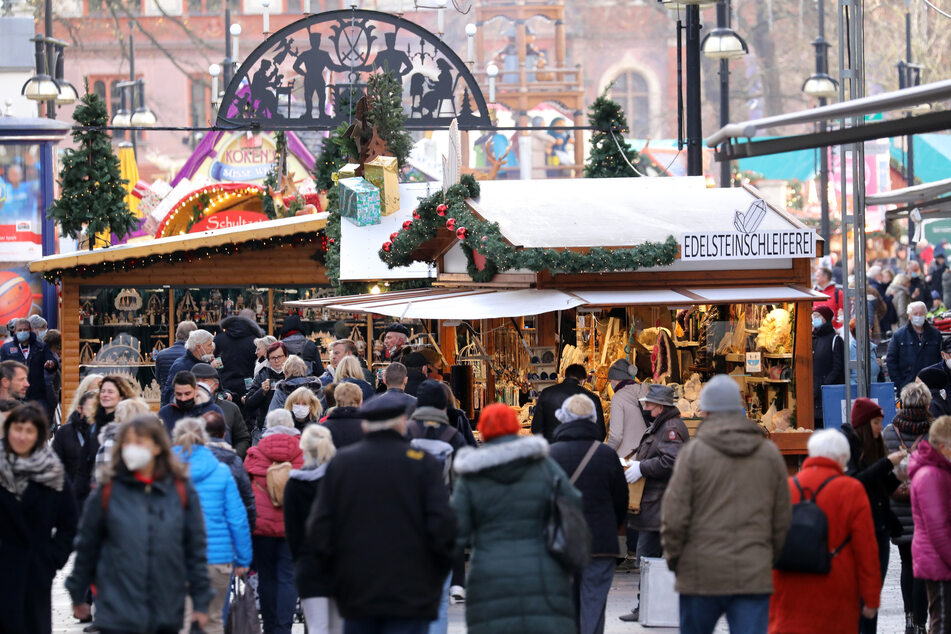 Passanten sind auf dem Weihnachtsmarkt in Rostock unterwegs. Die Zahl der Neuinfektionen ist weiter gestiegen.