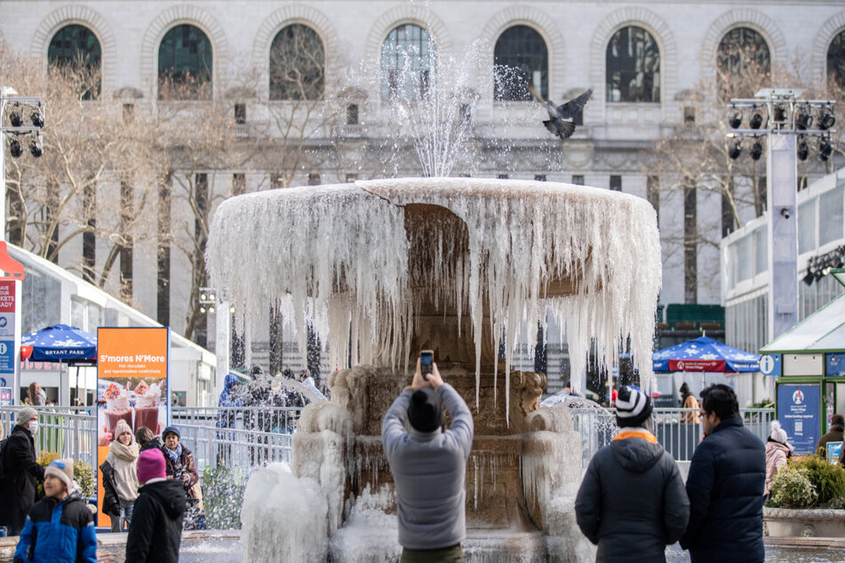 The Bryant Park fountain was mostly frozen during cold temperatures and high winds in New York City.