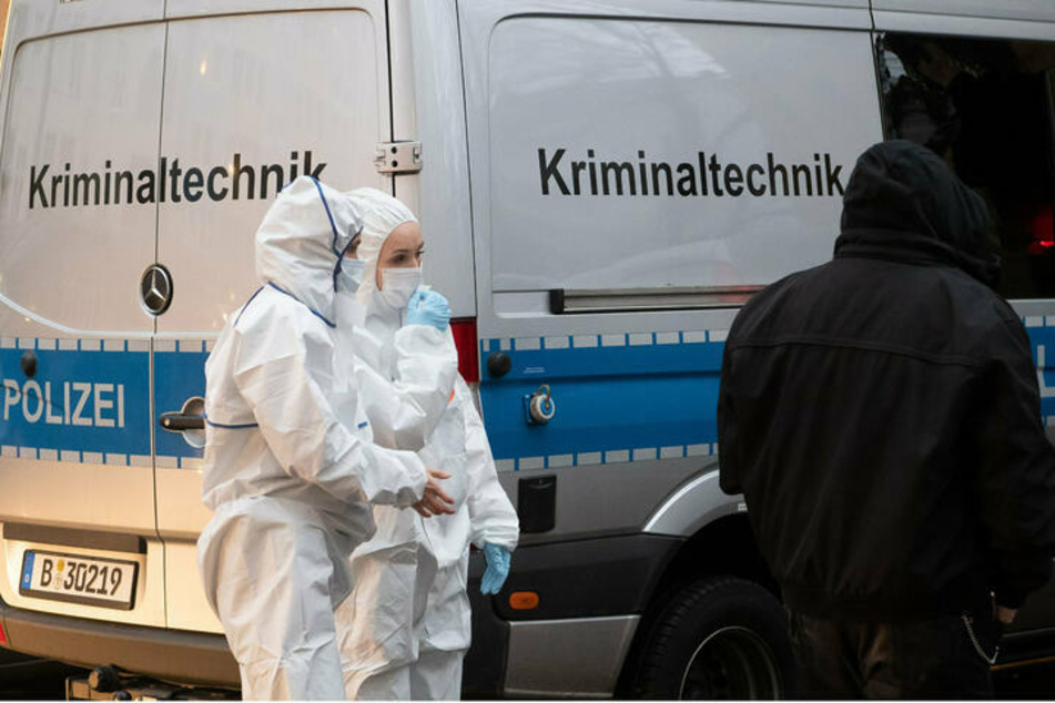 Kriminaltechnikerinnen stehen am 6. Januar 2021 an einem Einsatzfahrzeug vor einem Wohnhaus in der Mahlower Straße in Berlin-Neukölln.
