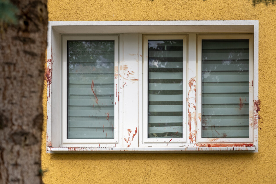 Das Fenster vor einer Wohnung des Mehrfamilienhauses in vollgeschmiert mit Blut.