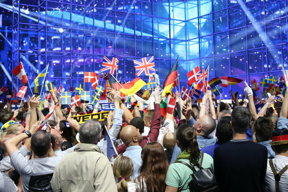 Fans schwenken internationale Papierfähnchen vor der Bühne des ESC-Finales. (Archivbild)