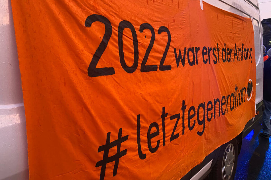 Ein Banner mit der Aufschrift "2022 war erst der Anfang" hängt an der Seite eines Transporters.
