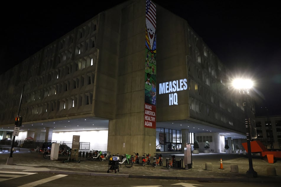 Protesters projected the title "MEASLES HQ" on the Department of Health and Human Services building in Washington DC amid a worsening epidemic.