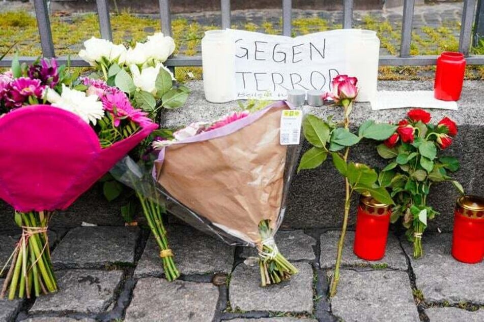 Blumen und Kerzen stehen nach der brutalen Messerattacke am Tatort in Mannheim.