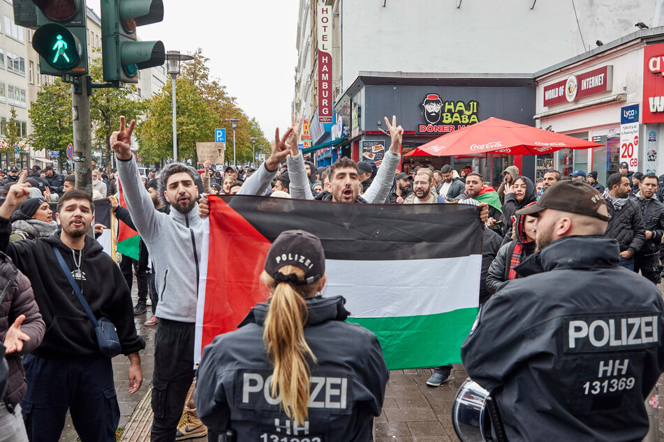 Demonstranten mit Palästina-Flaggen stehen umringt von Polizisten auf dem Steindamm in St. Georg. Die Versammlungsbehörde hat das Verbot entsprechender Demos verlängert.