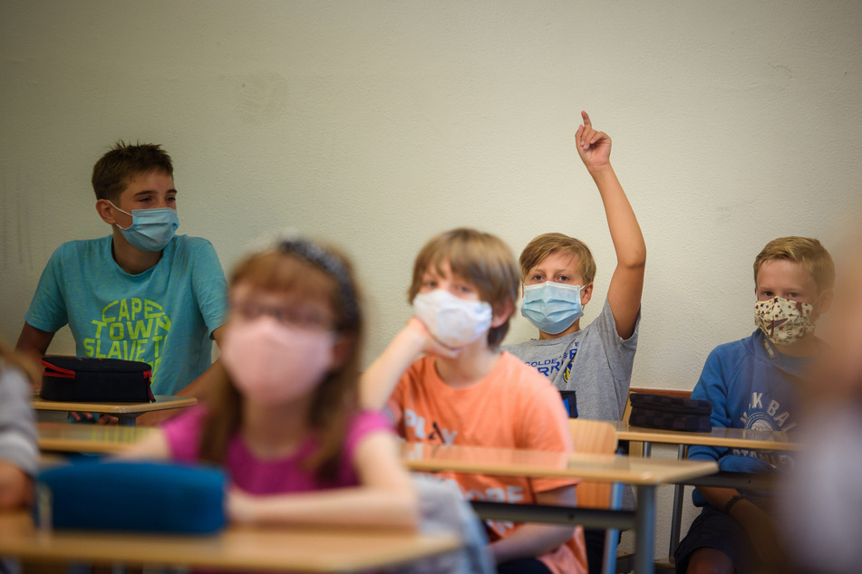 Ein Schüler einer Sechsten Klasse meldet sich zum Beginn des Unterrichts am ersten Schultag nach den Sommerferien an der Max-Planck-Schule in Kiel in einem Klassenraum.