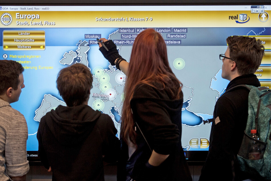 Besucher der Bildungsmesse Didacta im Jahr 2017 bedienen in der Messe Stuttgart ein interaktives Whiteboard.