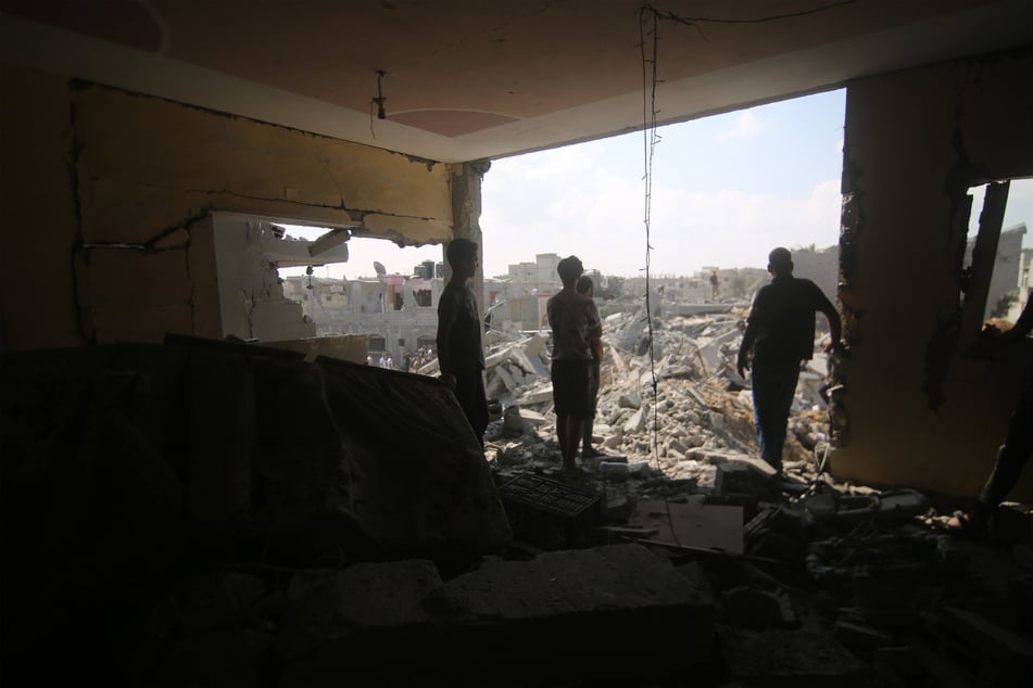 Palestinians look out over the rubble after an Israeli airstrike on Gaza.
