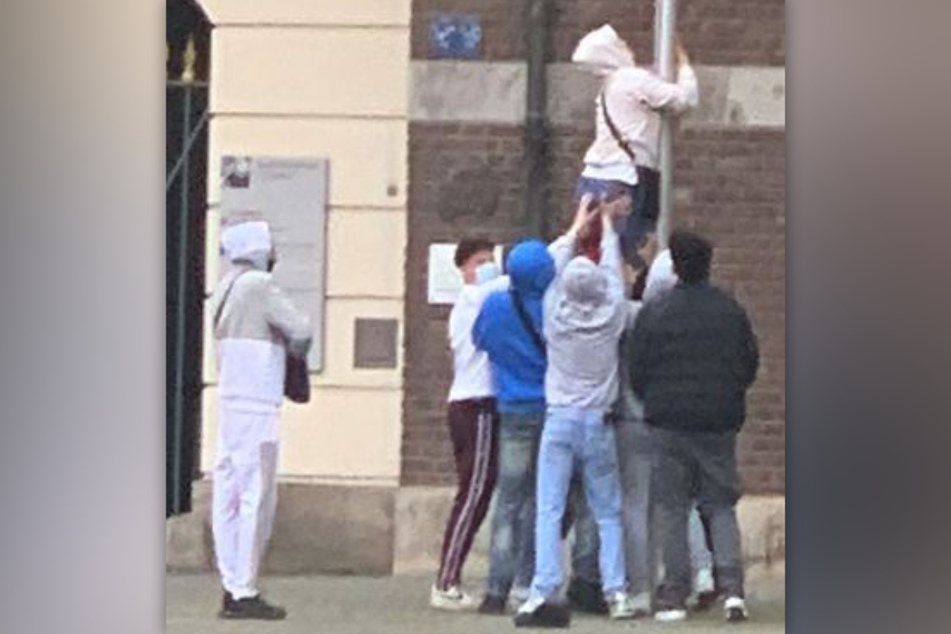 Um die Flagge zu erreichen, ist ein Jugendlicher am Mast hochgeklettert.